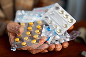 many different pills and medicines in the hands of an old man