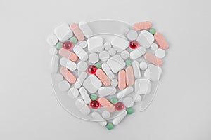 Many different pills on white background, laid out in form of heart. Concept of pharmaceuticals