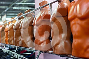 Many different plastic naked male mannequins in the clothing shop.