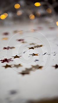 Many different plastic stars are surrounded by bokeh. The colors are multicolored and are the circular lights of the Christmas lig