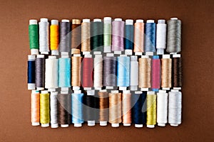 Many different reels with threads, flat lay, top view. Colored threads, close-up, bright background. Cutting and sewing clothes