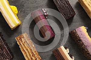 Many different tasty cakes on grey table, flat lay