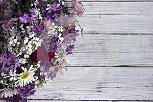 Many different types of flowers: purple and violet phlox, white daisy, pink bells