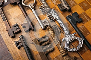 Many different vintage keys on a wooden background