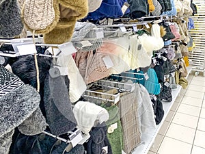 Many different warm winter knitted caps, hats in a clothing shop, store, winter sale in supermarket