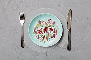 Many different weight loss pills and supplements as food on round plate. Pills served as a healthy meal. Drugs, pharmacy