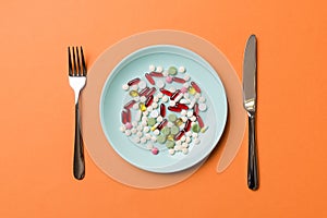 Many different weight loss pills and supplements as food on round plate. Pills served as a healthy meal. Drugs, pharmacy