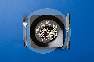 Many different weight loss pills and supplements as food on round plate. Pills served as a healthy meal. Drugs, pharmacy