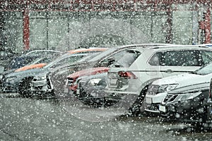 Many differents cars are parking during heavy snowing in winter season.