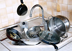 Many of dirty dishes in the sink in kitchen