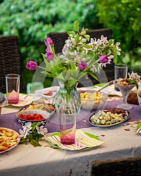 Many dishes on the table. Table decorated with flowers.