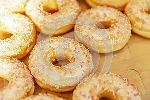 Many donuts with yellow icing on the counter in a store. Traditional mouth-watering sweets. Close-up