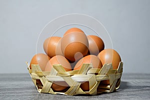 Many eggs in a small bamboo basket on the gray wooden floor, Chicken eggs contain protein and many other nutrients, all of which