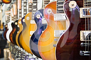 Many electric guitars body aligned in the store