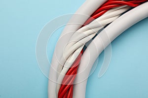 Many electrical cables on light blue background, closeup