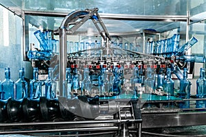 Many empty bottles on a conveyor belt at alcoholic beverage factory