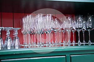 Many empty glasses for alcoholic beverages. glass goblets on the shelf.
