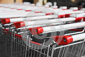 Many empty metal shopping carts, closeup view