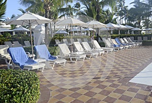 Many empty pool lounge chairs