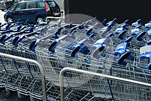 Many empty shopping carts near supermarket, closeup