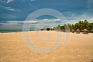 Many empty sun loungers on the deserted beach of Hainan Island.