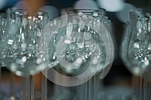 Many empty transparent drinking glasses, wine glasses on the table in the restaurant