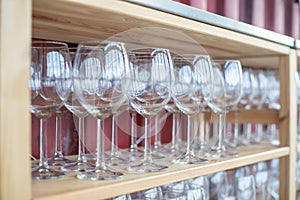 many empty wine glasses arranged on wooden shelves