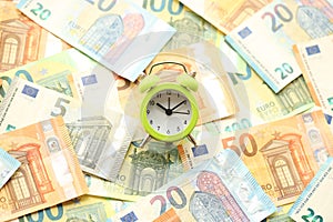 Many European euro money bills and alarm clock. Lot of banknotes of European union currency