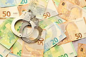 Many European euro money bills and handcuffs. Lot of banknotes of European union currency and cuffs