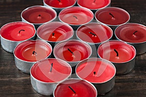 Many extinguished red candles closeup