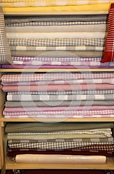Many fabrics for sale in the shelf full of haberdashery
