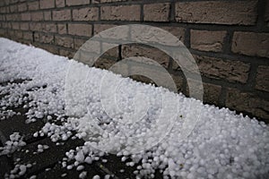 Many fallen hailstones against the wall in spring.