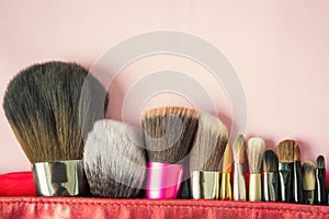 Many fashion brush for makeup or cosmetic in red bag on blurred