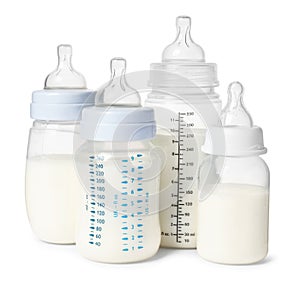 Many feeding bottles with infant formula on white background