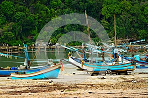 Many fishing boats moored on the beach by the sea..