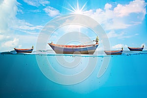 Many fishing boats on the sea waves stop steaming, with separate bubbles on a bright sky background, the morning sun. Popular