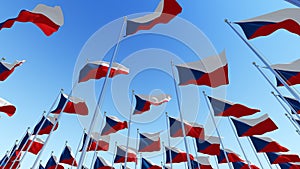 Many flags of Czech Republic in front of blue sky.