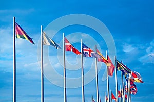 Many flags of different countries against the sky