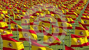 Many flags of Spain in green field.
