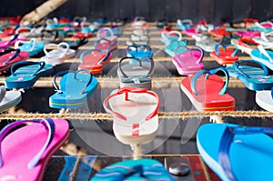 many flip flop sandals aligned on a string