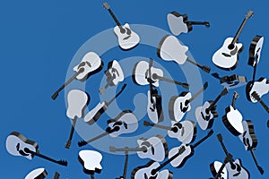 Many of flying acoustic guitars isolated on blue background.