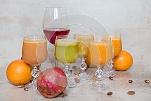 Many fresh juice mix vegetables and fruit, healthy drinks on grey table.