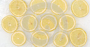 Many fresh lemon, top view of water flowing on a white background