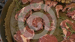 Many fresh raw and juicy large pieces of steak are fried on a barbecue grill with a young potato. Tenderloin. Elite meat