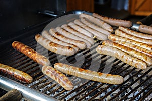 Many fried sausages on the charcoal grill, typical fast food in Germany on the street or at an open air festival