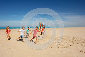 Many friends kids run with color kite on the beach