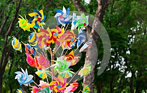 Many fun colorful pinwheels spinning in the wind at a carnival p