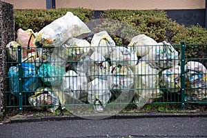 Many garbage bags lie in the front yard