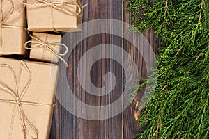 Many gift box on dark rustic wooden background with copy space. Christmas fir tree branches. Christmas conceps