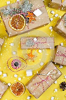 Many gift boxes on Illuminating yellow background with snow flakes. Christmas holiday packaging wallpaper
